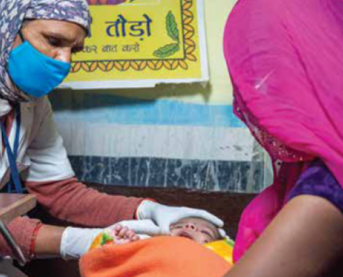 A healthcare worker attending a baby while the baby's mother is watching. Credit: UNICEF