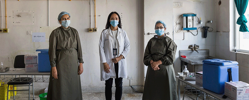 Three healthcare workers in a clinic wearing masks