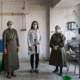 Three healthcare workers in a clinic wearing masks