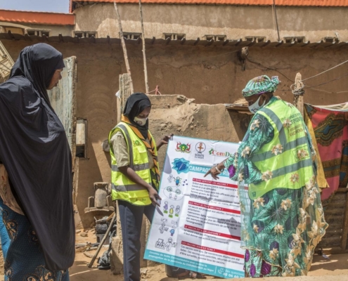 Nigerian healthcare workers explaining COVID-19 vaccines to a woman. Photo credit: UNICEF Niger/Islamane