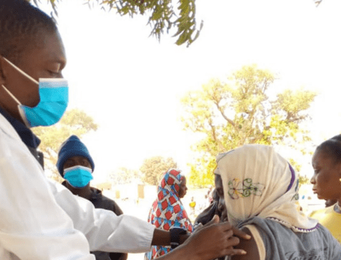 A health worker in Burkina Faso administering a COVID-19 vaccine