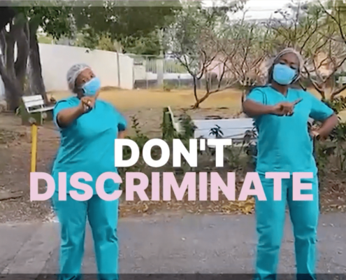 Two nurses dancing with the words "Don't Discriminate" on the screen