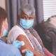 An elderly woman receiving a vaccine