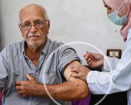 A healthcare worker administering a COVID-19 vaccine to an elderly man. Photo credit: WHO