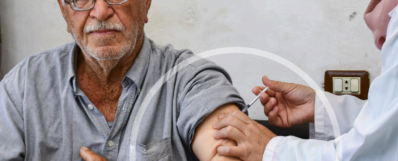 A healthcare worker administering a COVID-19 vaccine to an elderly man. Photo credit: WHO